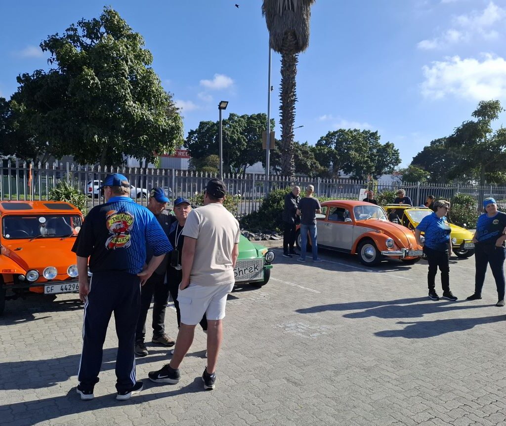 A group of Wild Buggers gathers at the meeting point, socializing and admiring the lineup of classic cars before the run.