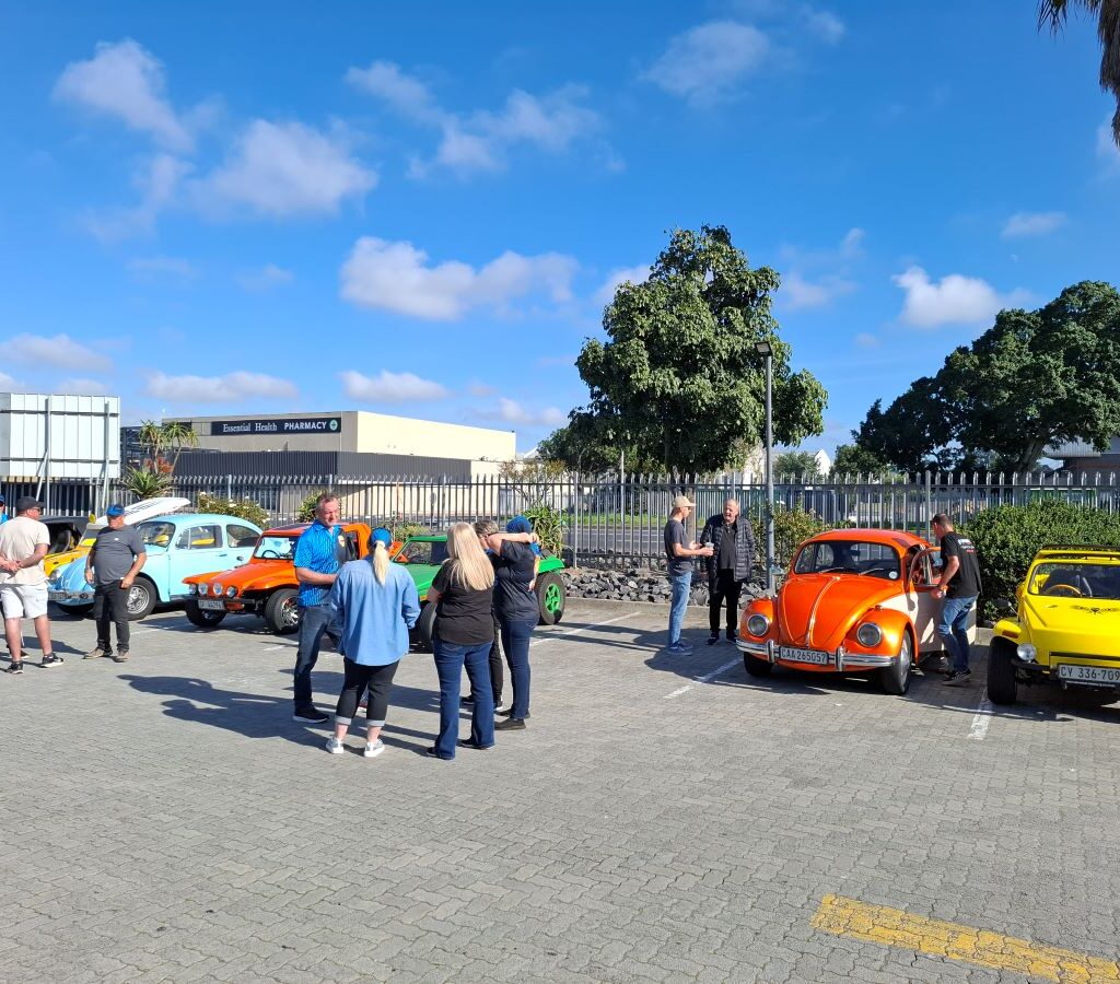 Members of the Wild Buggers club gather and chat at the meeting point before their run, surrounded by their VW Air cooled vehicles.