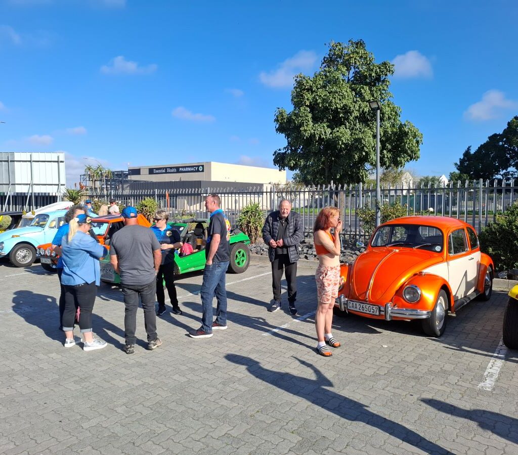 A group of Wild Buggers club members laughing and socializing at the meeting point before their run.