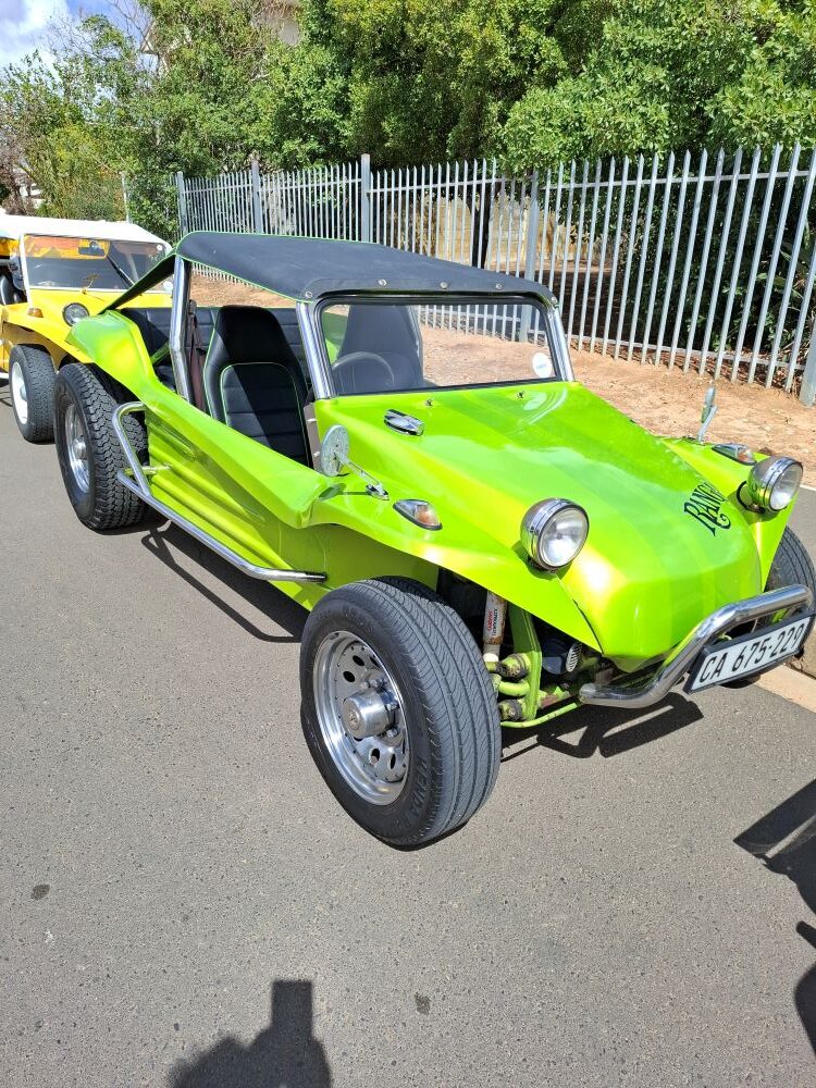 Alt Text: A custom bright lime-green VW air-cooled Beach Buggy named "Rango" parked on an asphalt road during a Wild Buggers club event.