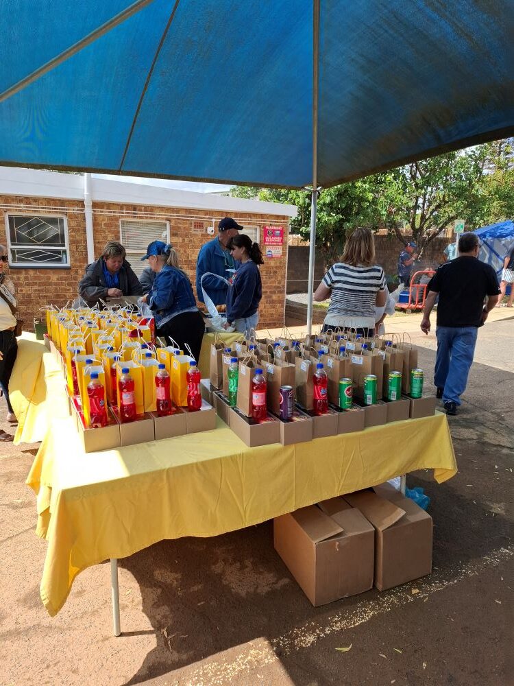 Wild Buggers club members and volunteers preparing gift packs and drinks for residents at the Badisa Goue Aar charity event.