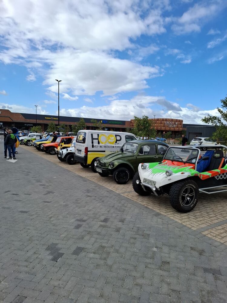 A line of custom Beach Buggies, Baja Bugs, and VW classic vehicles parked at the Groot Phesantekraal View meeting point in Durbanville.