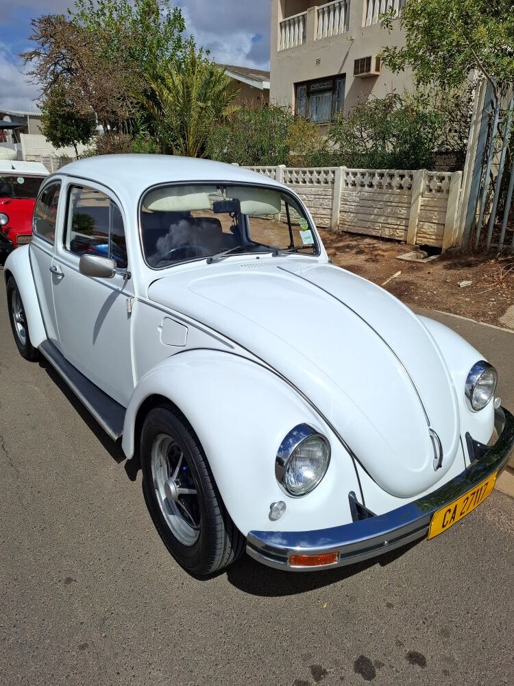 A pristine white 1975 VW Beetle owned by Andre and Jo-ann Gericke, parked on a residential street during a Wild Buggers club event.