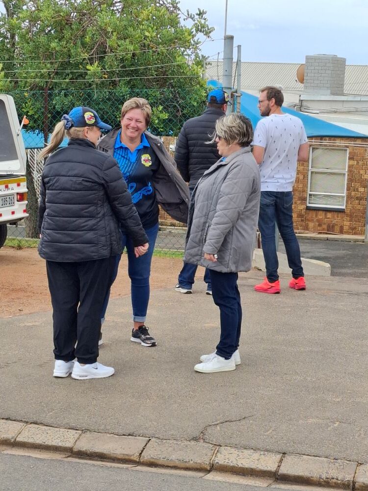 hree female members of The Wild Buggers Beach Buggy Club chatting and laughing outdoors at the Goue Aar home.