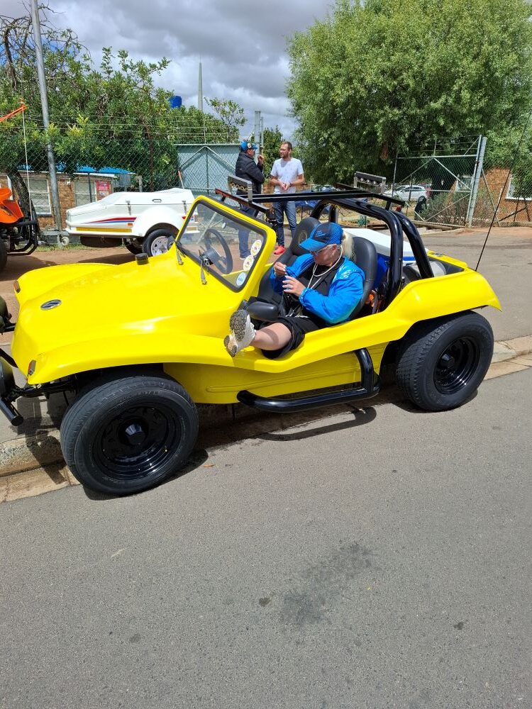 Michelle Jenkins relaxing in the passenger seat of a bright yellow Beach Buggy during the Wild Buggers charity run.