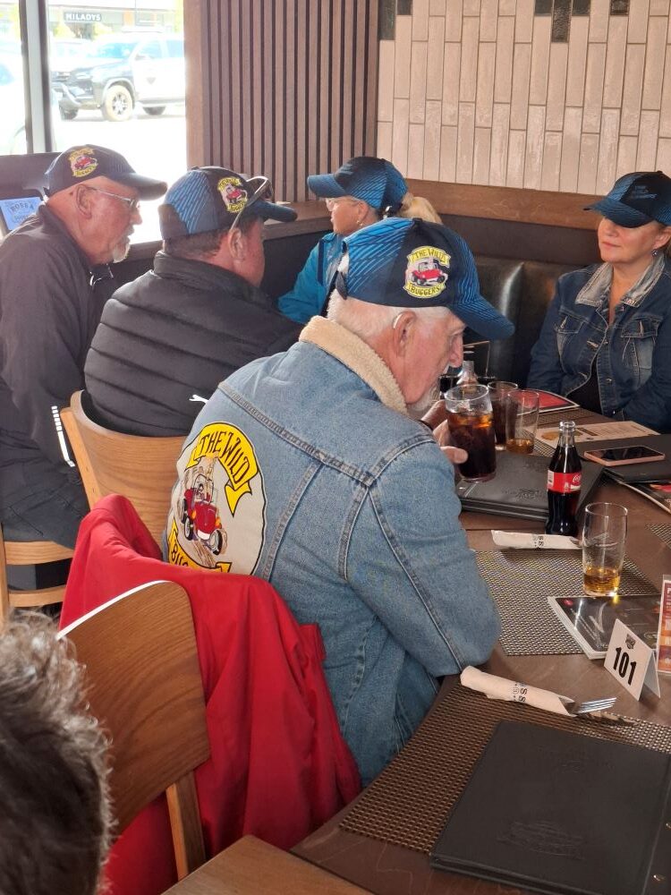 The Wild Buggers Beach Buggy Club members sitting around a restaurant table after completing a roadside beach buggy repair.