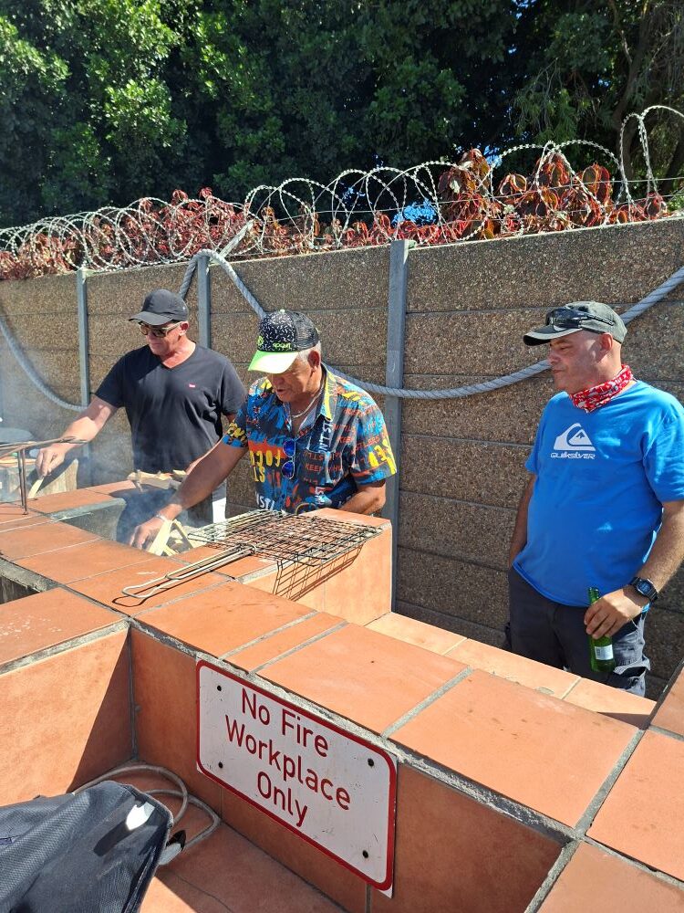 Brent, Wiehann, and Faizal from the Wild Buggers Beach Buggy Club tending to a braai at the Oceana Power Boat Club social event.