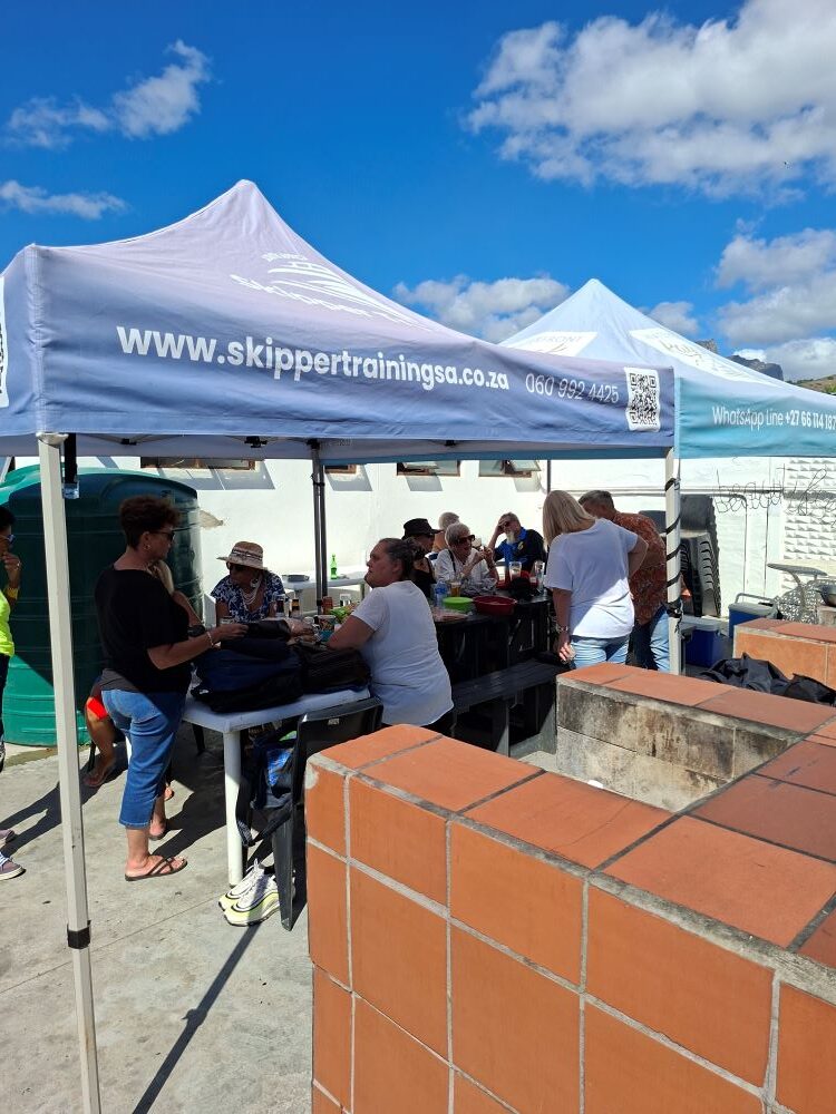 Wild Buggers Beach Buggy Club members enjoying a social gathering under branded gazebos at the Oceana Power Boat Club after a coastal run.