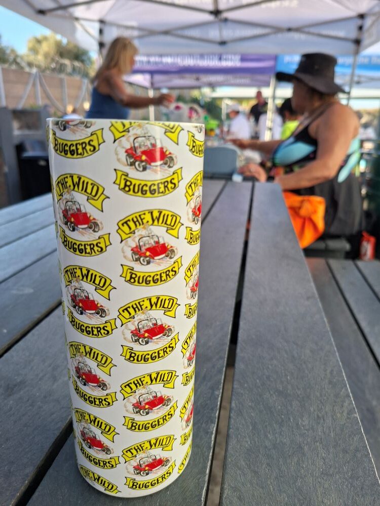 A white Wild Buggers Beach Buggy Club branded travel mug on a wooden table at Oceana Power Boat Club.