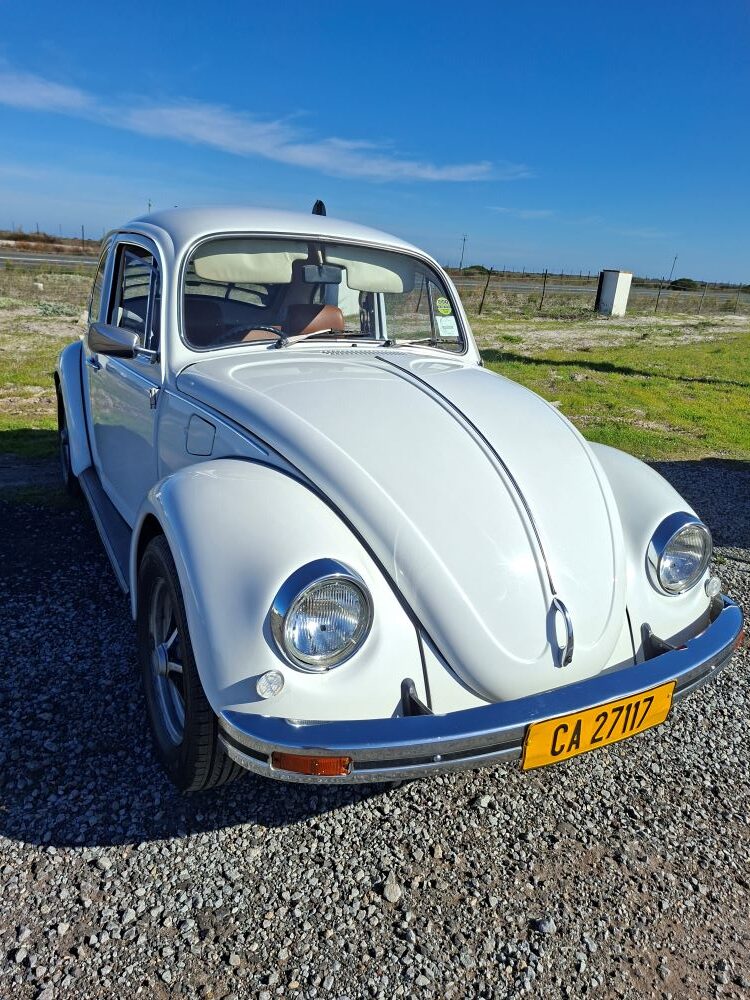 Andre and Jo-ann Gericke’s white 1975 VW Beetle parked at a West Coast pitstop during the Wild Buggers West Coast cultural experience Run, showing off classic Volkswagen style on a scenic club outing.