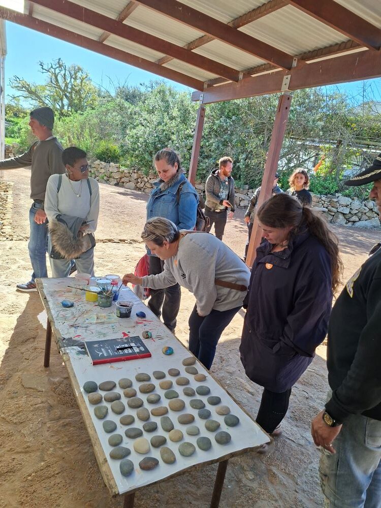 Wild Buggers members gathered at the stone-painting table at !Khwa ttu during the West Coast cultural experience Run, getting ready to paint stones for the large Africa-shaped ground artwork at the San Heritage Centre.