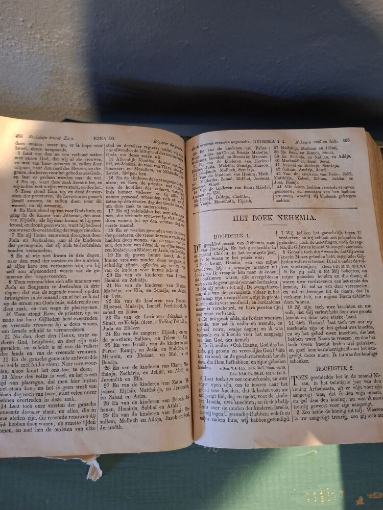 An open antique Bible on display inside a museum at !Khwa ttu during the Wild Buggers West Coast cultural experience Run, appearing to be written in old Dutch and highlighting a historic exhibit at the San Heritage Centre.