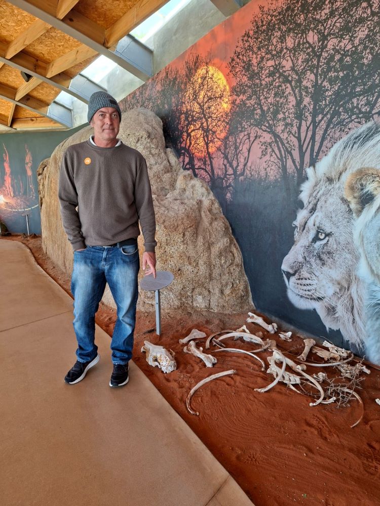 Rhoodie posing next to an animal skeleton display at !Khwa ttu during the Wild Buggers West Coast cultural experience Run, adding a fun wildlife-and-history moment to the San Heritage Centre visit.