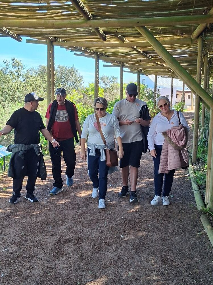 Wild Buggers club members chatting while walking back to their classic VW beach buggies and Volkswagens in the parking lot at !Khwa ttu during the West Coast cultural experience Run.