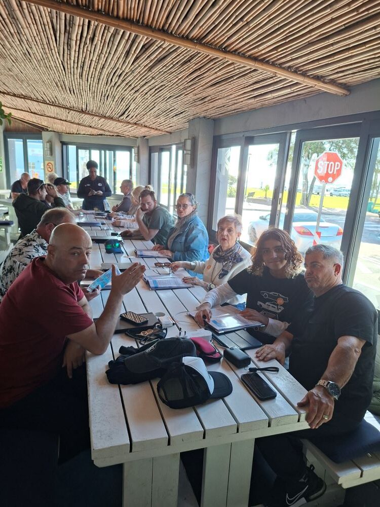 Wild Buggers club members chatting and laughing around the lunch table at the Seafood Lapa restaurant in Melkbosstrand during the final stop of the West Coast cultural experience Run.