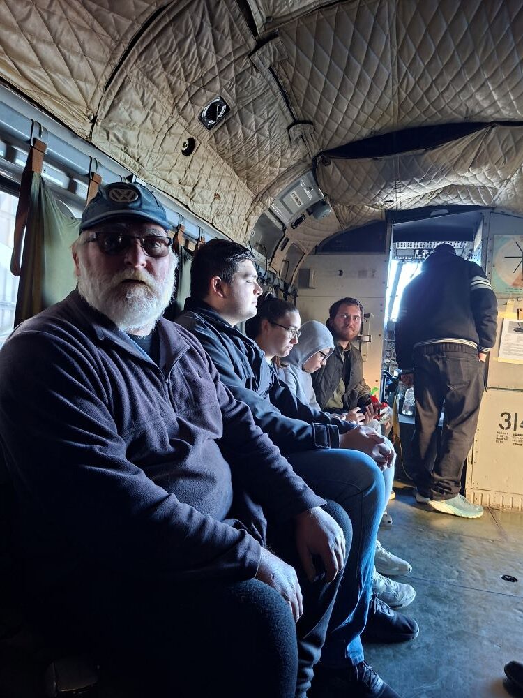 Wild Buggers club members sitting inside the cargo hold of a vintage Aérospatiale SA 321 Super Frelon troop carrier helicopter at the Ysterplaat museum during a classic VW air-cooled vehicle event.