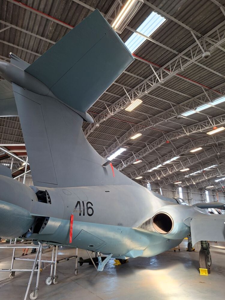 A side view of the rear fuselage and jet exhaust of a vintage Blackburn Buccaneer strike aircraft with tail number 416 on display inside the hangar during a Wild Buggers classic car club run.
