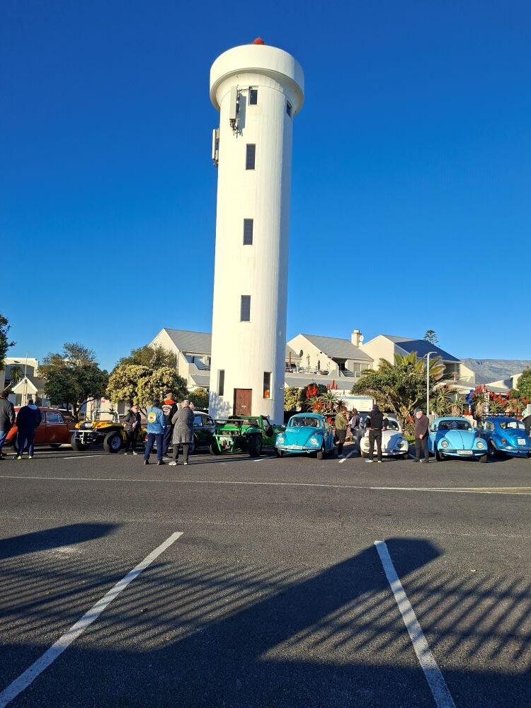 Classic VW Beetles and custom beach buggies parked at the Woodbridge Island meeting point by the Milnerton lighthouse for a Cape Town car club run.