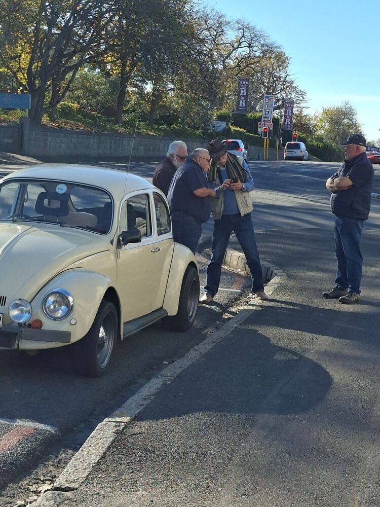 Hugo showing fellow club members his mechanical projects and explaining how to fit an A15 Datsun motor into a classic VW Beetle during the Wild Buggers Beach Buggy Club Propellers and Pistons Winter Cruise.