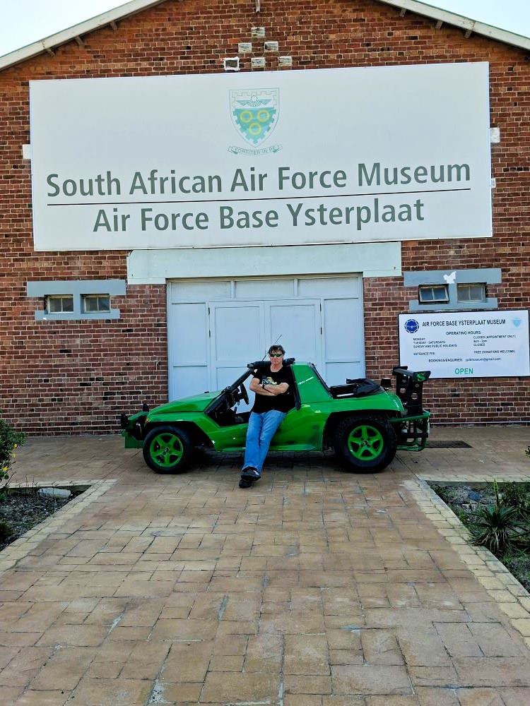 Anton Kleyn leaning against his green Kango beach buggy named Shrek outside the South African Air Force Museum at Air Force Base Ysterplaat during a classic car club cruise.
