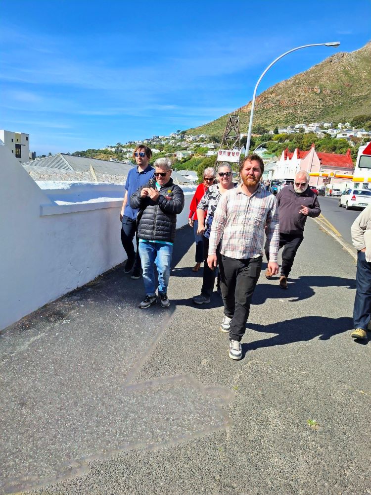 Wild Buggers club members walking together toward the South African Naval Museum in Simon's Town during the From Bars to Battleships run, featuring classic VW air-cooled vehicle enthusiasts.
