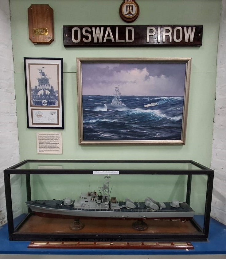 Museum display featuring a scale model and paintings of the strike craft SAS Oswald Pirow inside the South African Naval Museum in Simon's Town.