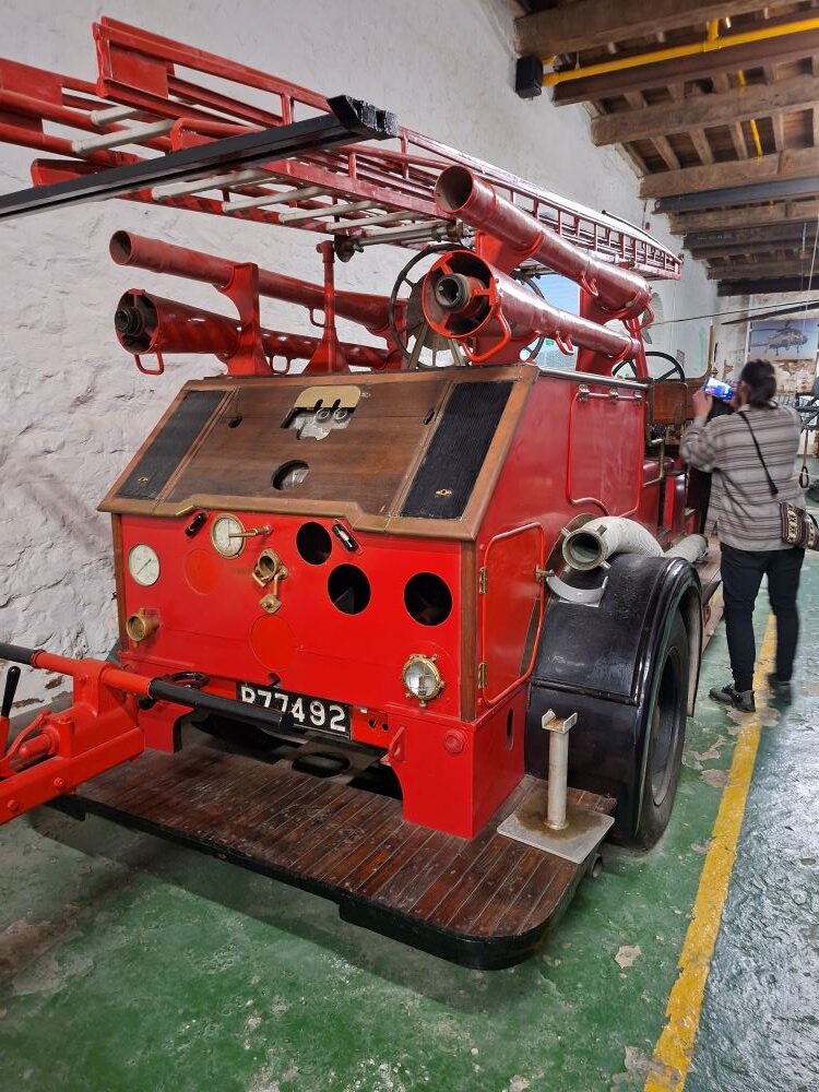A vintage fire engine and historical firefighting equipment on display inside the Mast House at the South African Naval Museum.