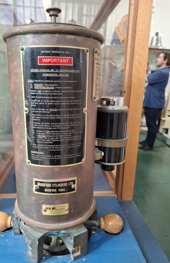 A historical Oxygen Generator Mk 1 on display with pyrotechnic ignition instructions inside the naval museum.