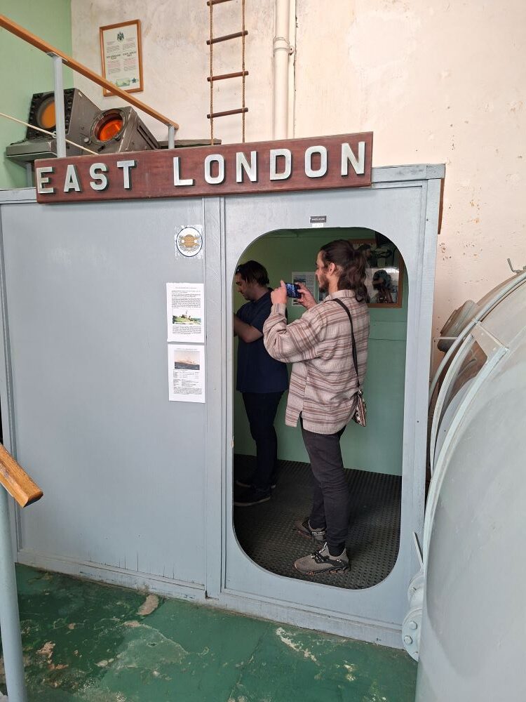 Club members exploring the East London wheelhouse replica exhibit inside the South African Naval Museum.