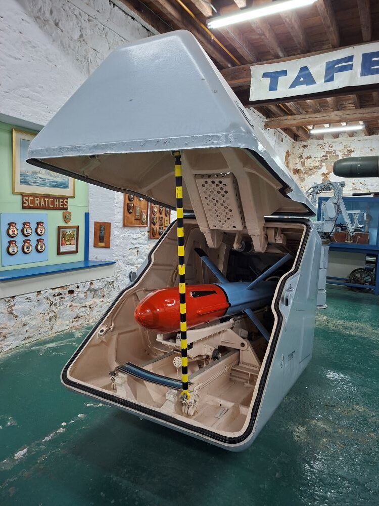 An open housing container revealing a missile on display inside the South African Naval Museum.