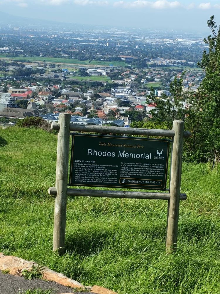 The informational sign for Rhodes Memorial overlooking the expansive landscape of Cape Town.