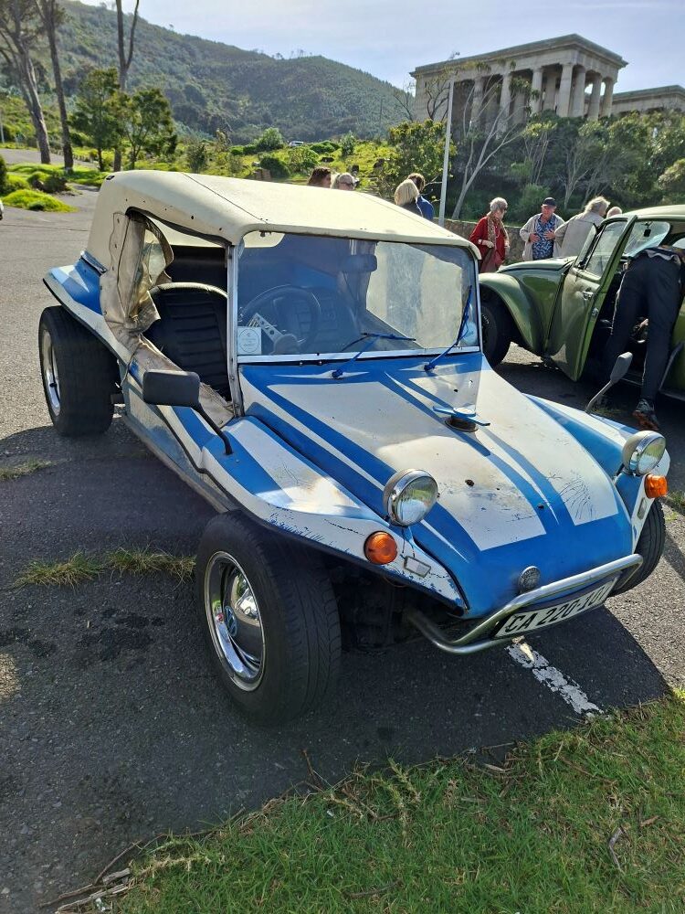 Harvey Metcalf's white and blue Beamish beach buggy parked at Rhodes Memorial with club members gathering in the background.