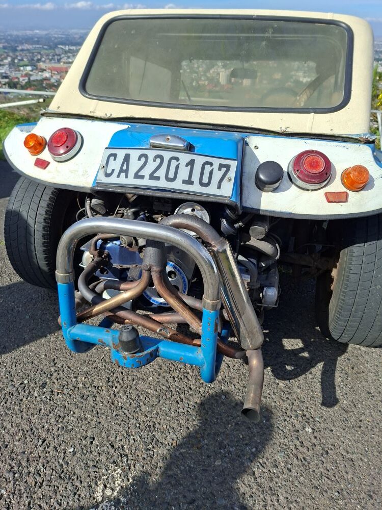The rear view of Harvey Metcalf's white and blue Beamish beach buggy showcasing its exposed air-cooled engine and custom exhaust.