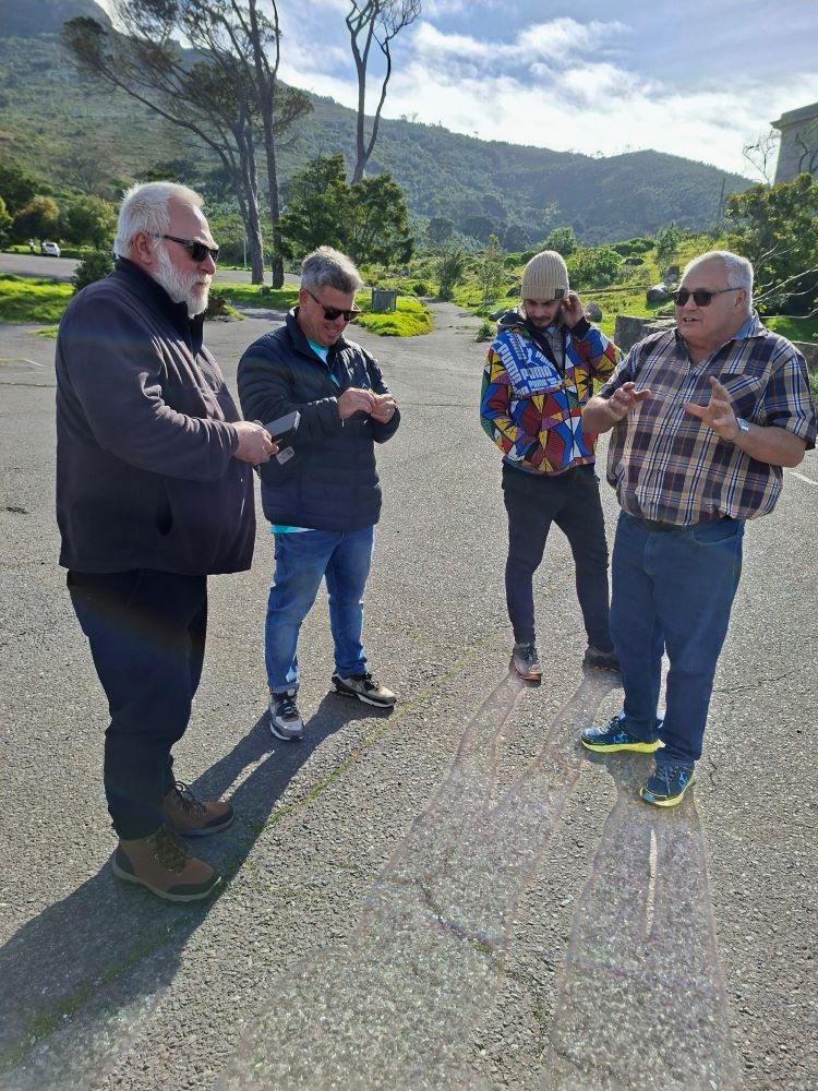 Club members standing together and chatting outside at Rhodes Memorial during the club run.