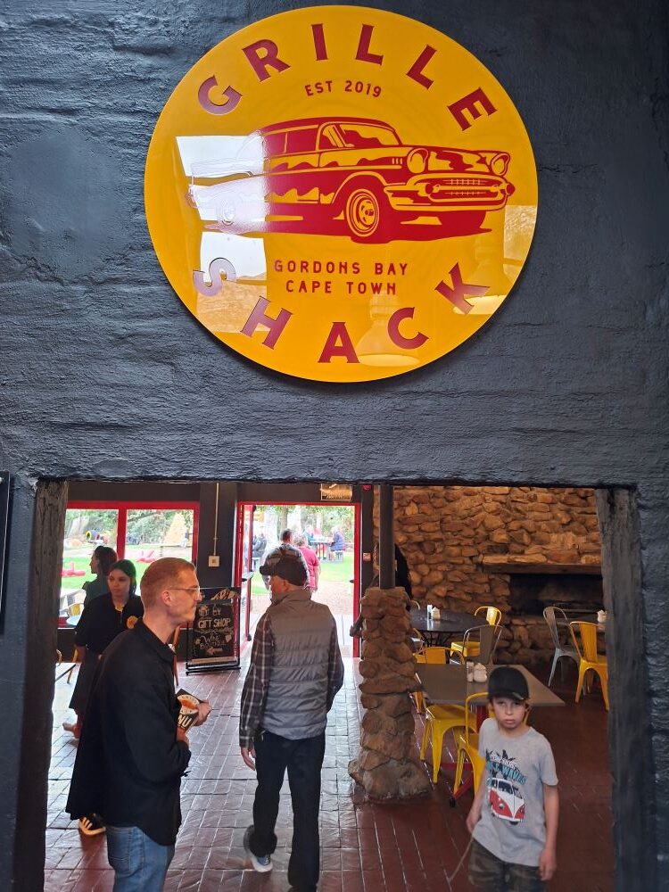 The prominent round sign of The Grille Shack welcoming club members during the scenic drive stop.