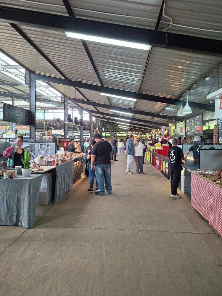 Club members exploring the busy interior walkways and artisanal food stalls during the stop at Lourensford Market.