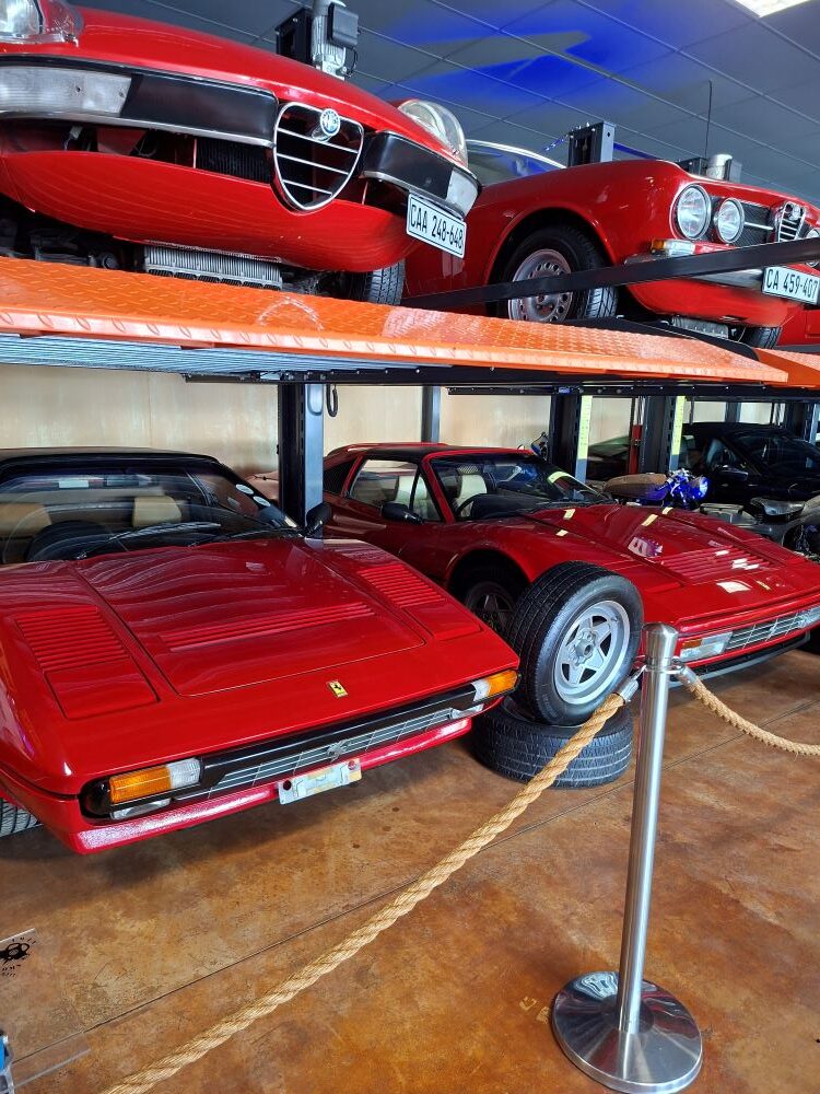 A collection of classic vintage red Ferraris and Alfa Romeos displayed indoors at Lourensford Estate.