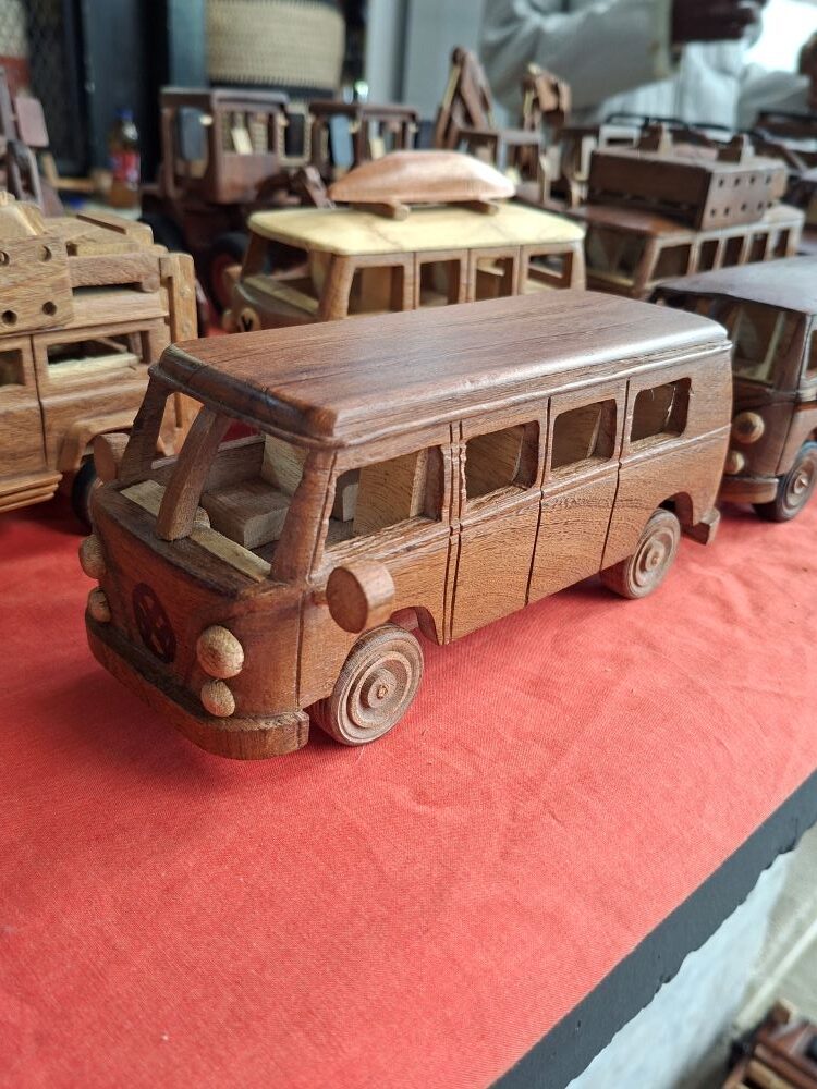 A handmade wooden model of a classic VW Kombi bus on display at a market stall during the club outing.