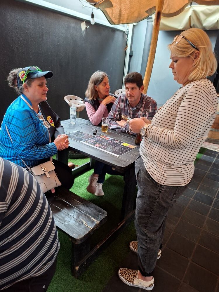 Club members gathered around a table at The Bacon Spot in Strand to enjoy a meal together during the convoy stop.